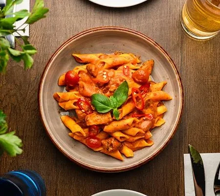 Velvety Indo-Italian fusion butter chicken penne pasta garnished with herbs