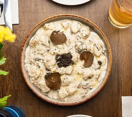 Handcrafted potato dumplings in rich truffle mushroom cream sauce at Epicurean
